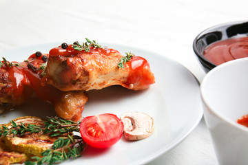 Plate of roasted chicken with barbecue sauce on table, closeup