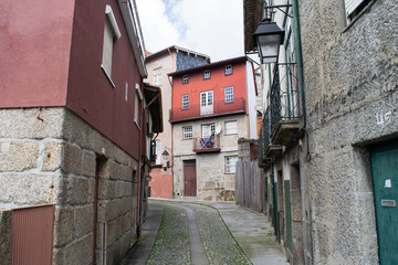 Narrow cobbled street weaving down between traditional buildings in Guimaraes, Portugal