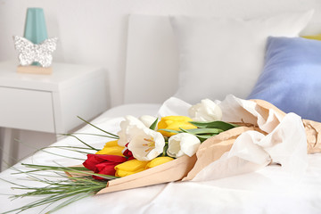 Fototapeta na wymiar Beautiful flowers as gift on bed
