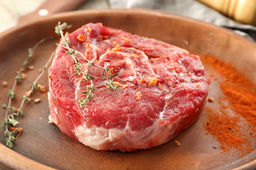 Fresh raw meat with thyme on plate
