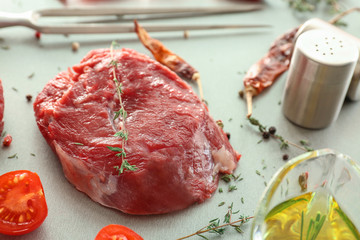 Fresh raw meat with thyme on kitchen table