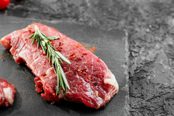 Fototapeta na wymiar Fresh raw meat with rosemary on slate plate