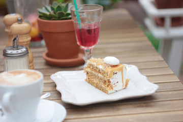 The piece of cake on table of summer terrace in cafe, picnic, set table