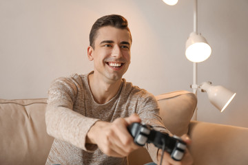 Young man playing video game at home