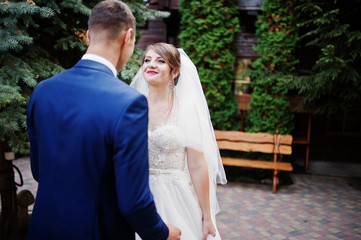 Naklejka premium Young beautiful wedding couple walking and posing at picturesque territory.