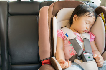 Toddler girl sleeping in her car seat.