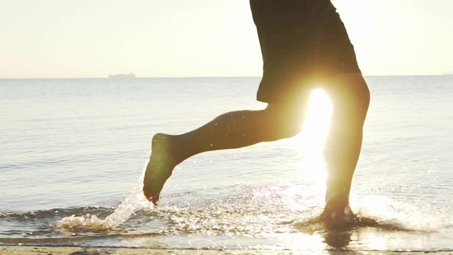  barefooted runner training on the morning beach during sunrise