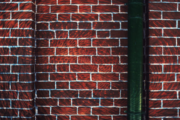 Hallucinogen red surreal brick wall with green downspout. Asymmetric angle of exotic brown fluorescent uneven wall in perspective. Haunted imagination from drugs and alcohol. Drain pipe is in right.