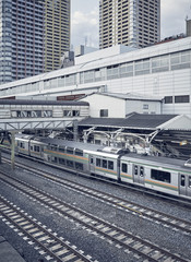 Commuter electric train in Tokyo stopped in a train station. It operates between capital and surroundings