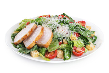 Caesar salad with chicken fillet and parmesan cheese isolated on white background.