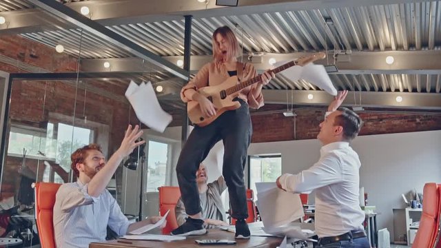 Happy successful start-up business team have fun dancing party in modern office throwing paper documents and celebrating success of project