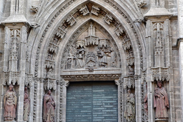 Fototapeta na wymiar Beautiful carved bas-relief and green door of Assumption, Sevilla Cathedral, Spain