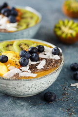 Freshly blended fruit smoothie with chia seeds, coconut flakes, kiwi and blueberries. Healthy breakfast.