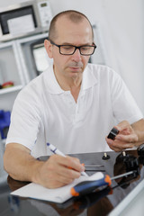 appliance technician writing his notes