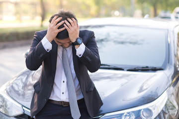 Handsome businessman with breakdown car on the road