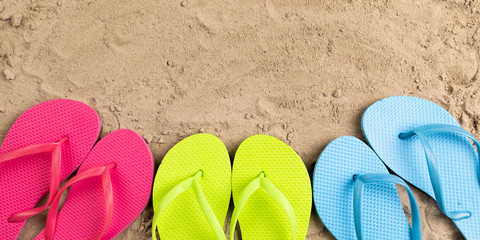 Fototapeta na wymiar colorful flip flops in sand