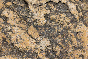 The surface of an old rock with cracks. Old rock texture (wild background)