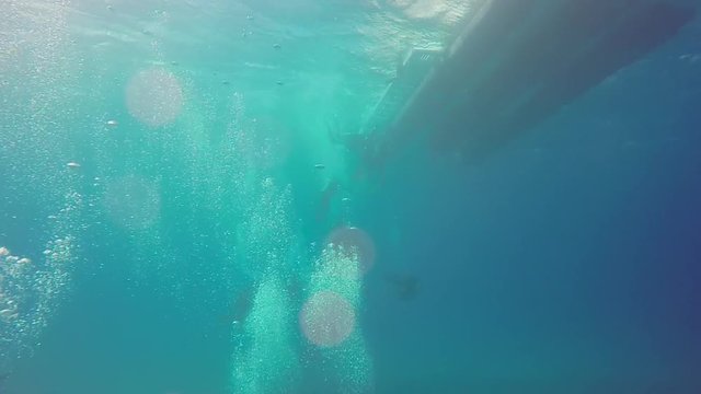 Scuba divers dive from boat in Hawaii.