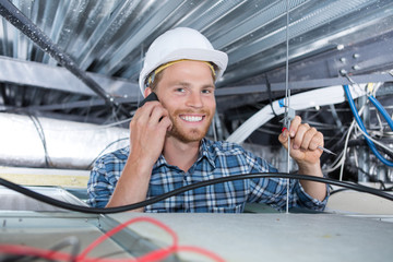 cheerful smiling builder working in the ceiling