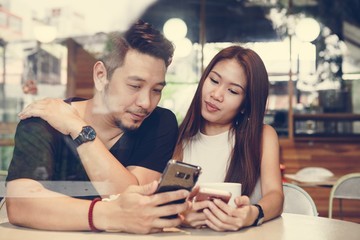 Couple using a phone at a cafe