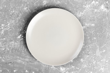 White matte round dish on the background of a gray rextured table