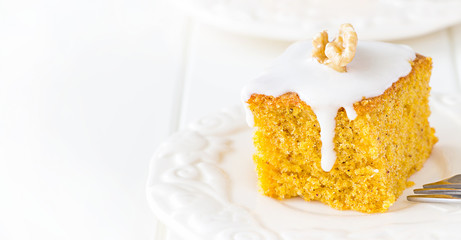 One piece homemade walnut carrot cake with icing cream white plate. Selective focus. Close up.