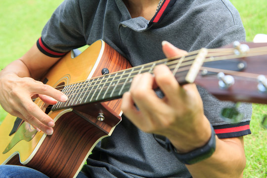 Musician playing Hamonic picking technic on acoustic guitar