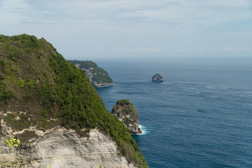 Fototapeta na wymiar Seascape, rocky coast, ocean, blue sea, waves, Nusa Penida, Indonesia. Ocean with waves and rocky cliff Travel concept
