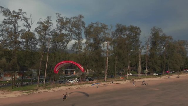Close-up paramotor flies very low along the sandy beach. The coast of Thailand. Trang province. Sikao. Paraglide. Para motor