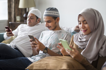 Fototapeta na wymiar Muslim friends using social media on phones