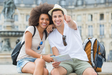 Obraz premium young tourists pointing at a sight in the city
