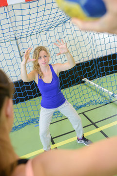 Female goalie at handball net