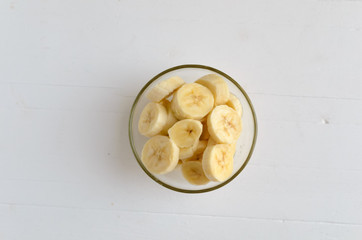 Fresh ripe organic sliced bananas in a glass bowl.Top view,Flatlay.