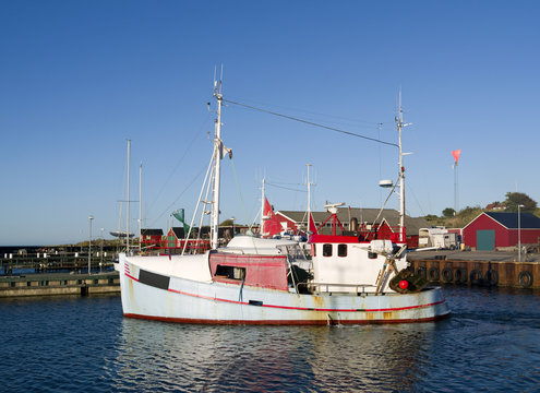 Laesoe / Denmark: A small fishing cutter leaves the harbor of Vesteroe Havn