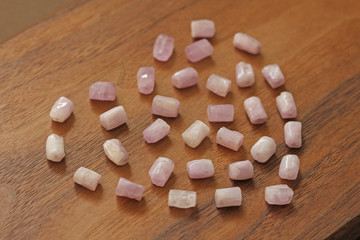 Pink heart on a wooden background. Kunzite is a natural pink stone for creating Jewelry. Natural...