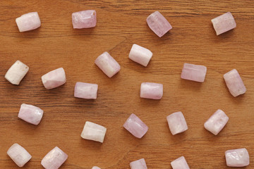 Kunzite is a natural pink stone for creating Jewelry on a natural wooden background. Natural...