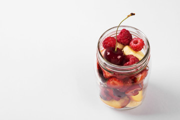 Various fruits and berries in a glass jar. Concept meals to go