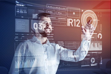 Happy web developer. Positive enthusiastic web developer feeling impressed while standing in front of a transparent screen and working with modern technologies