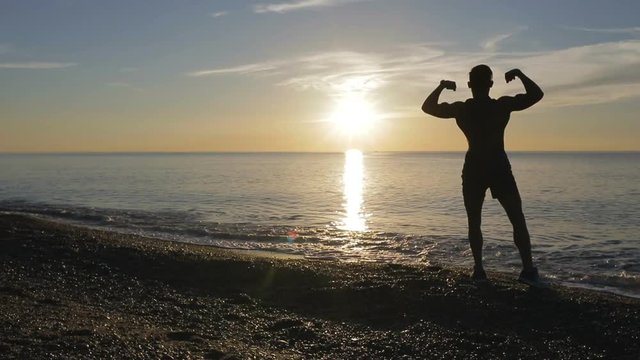 Silhouette di un ragazzo si sta allenando di fronte l'Oceano o il mare all'alba di mattina presto.