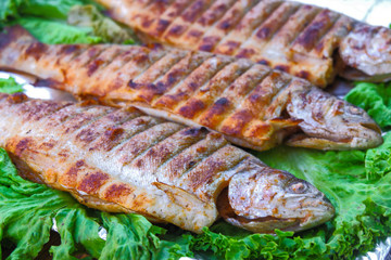 Fish mackerel on the grill on skewers with lemon