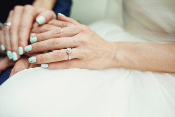 Groom holding bride's hand. Couple's hands.