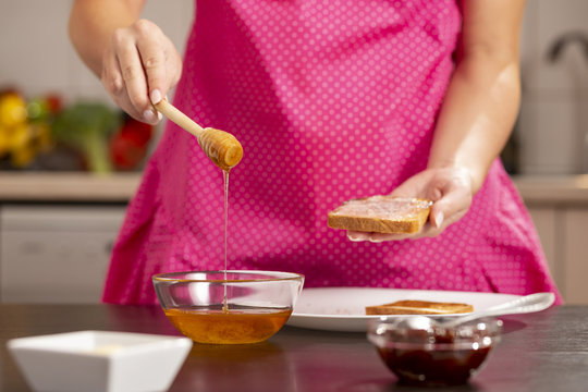 Woman making butter and honey sandwich