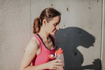 tired resting sports woman almost knockout after workout drinking a healthy shake from a bottle...
