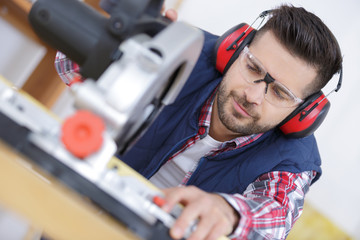 construction worker using slider compound mitre saw