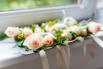 Fresh rose boutonnieres for the guests of the wedding.