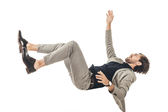frightened young businessman in suit falling isolated on white