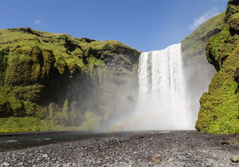 Stunning view of the famous Skogafoss waterfall in southern Iceland on a sunny summer day.