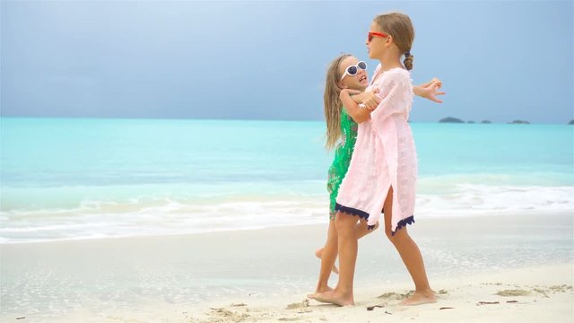 Adorable little girl having a lot of fun at tropical beach playing together