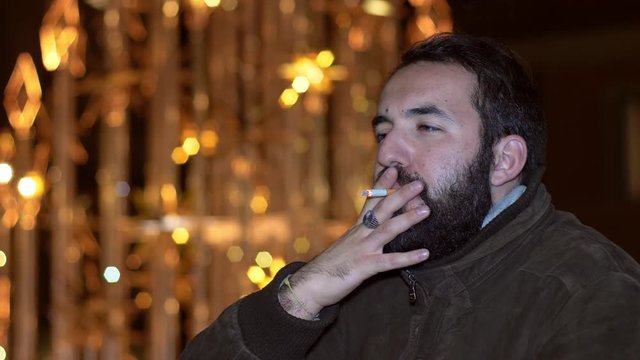 Thoughtful Handsome man smoking cigarette thinking- Christmas Time