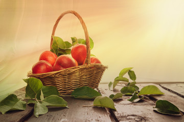 Peaches and nectarines in a wicker basket on a wooden table fruit harvest in a rustic style with a copy space